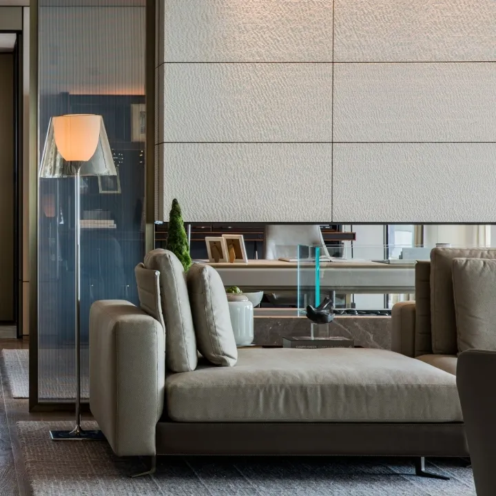 A stylish, modern living room with textured canvas seating, minimalist decor, and floor lamp.