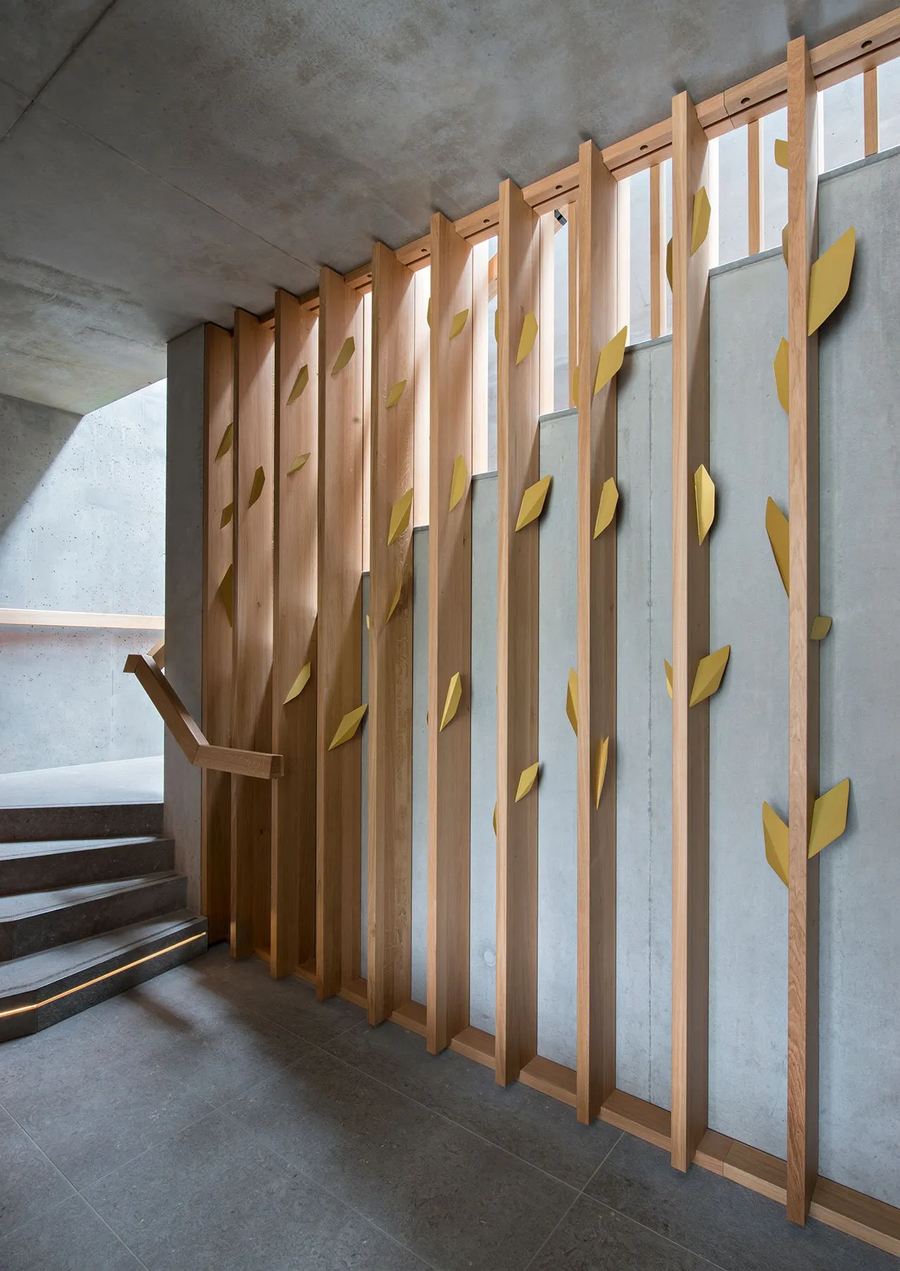 Modern stairwell featuring vertical wooden slats and concrete structural elements.