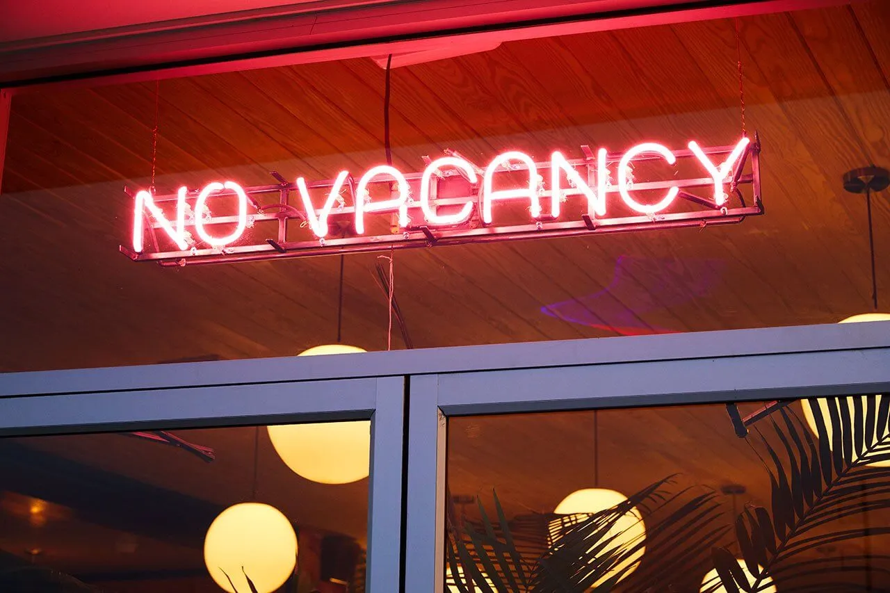 酒店或餐廳外掛著霓虹燈招牌,顯示「NO VACANCY」。