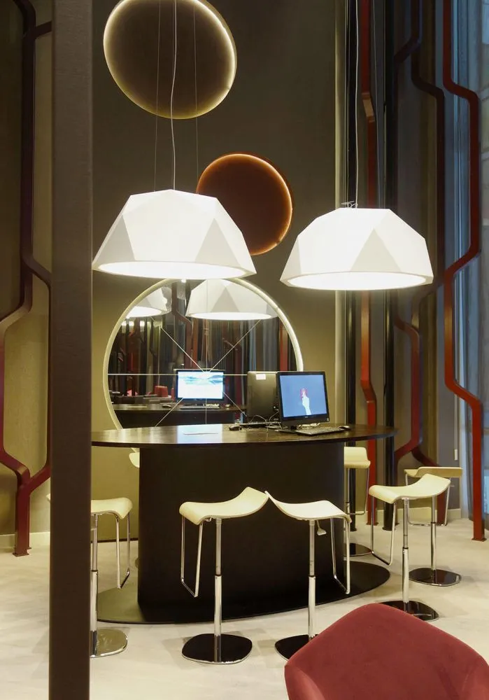 A modern industrial-style workspace with metal stools and a round counter.