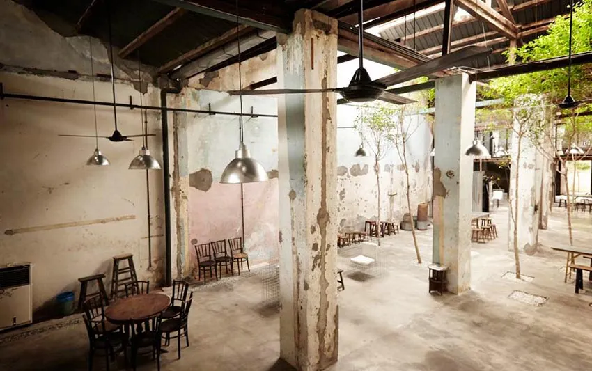 工業風餐廳室內,混凝土地板、鋼柱與玻璃吊燈。
