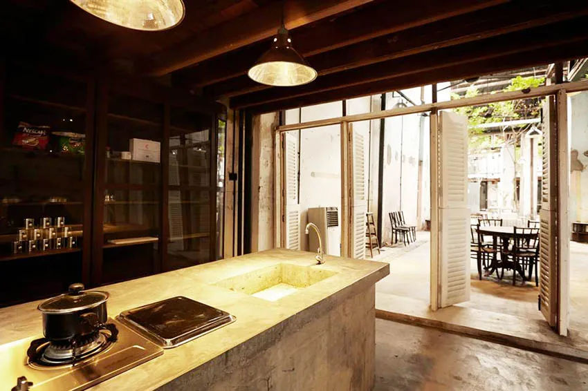 Industrial-style kitchen featuring concrete countertops and open layout.
