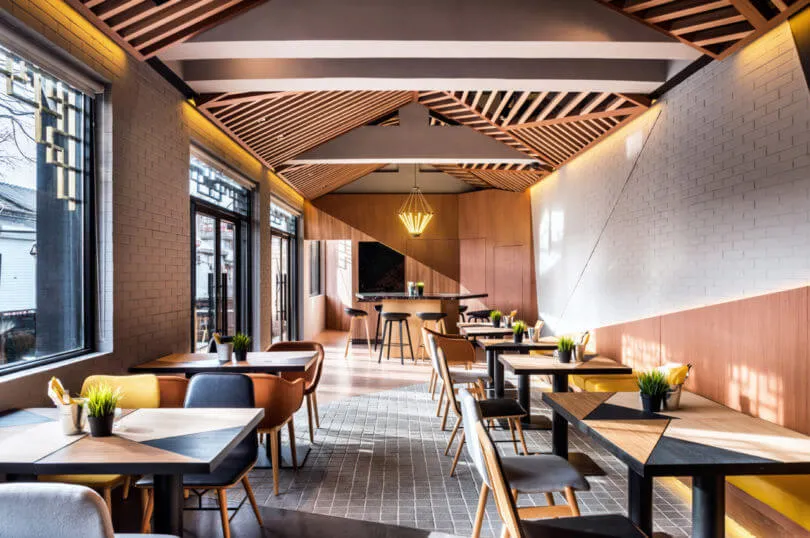 A modern restaurant interior featuring wood and brick materials.