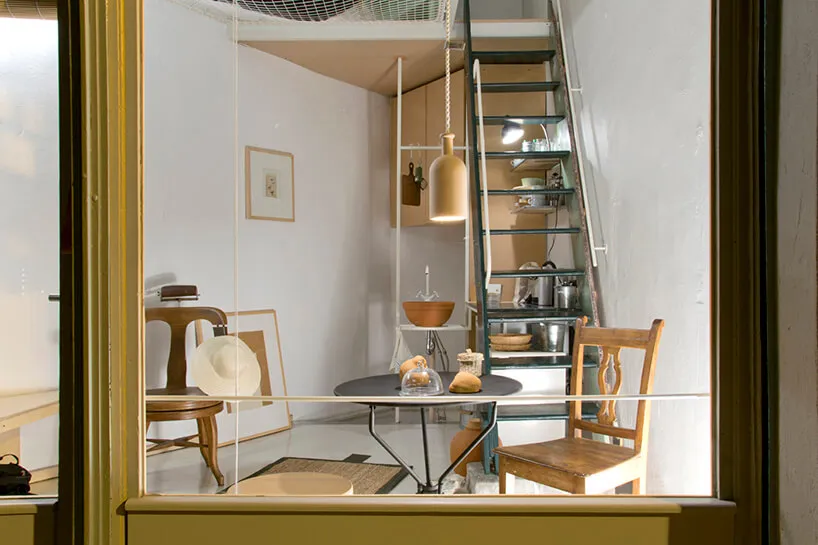 Industrial-style residential interior with wooden furniture, metal stairs, and ceramic items.
