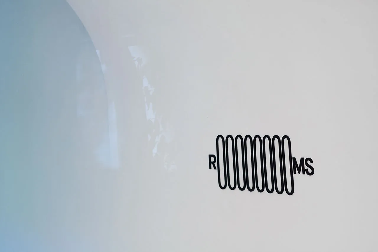 A minimalist logo design featuring a metallic representation of the letters RMMS on a white background.