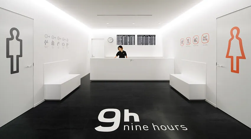 極簡風格的白色辦公室接待區,搭配黑色地板與細緻的標示牌。