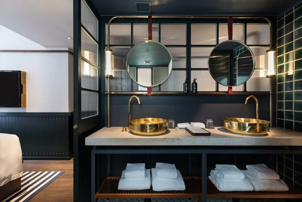Modern bathroom with metallic gold sinks and mirrors