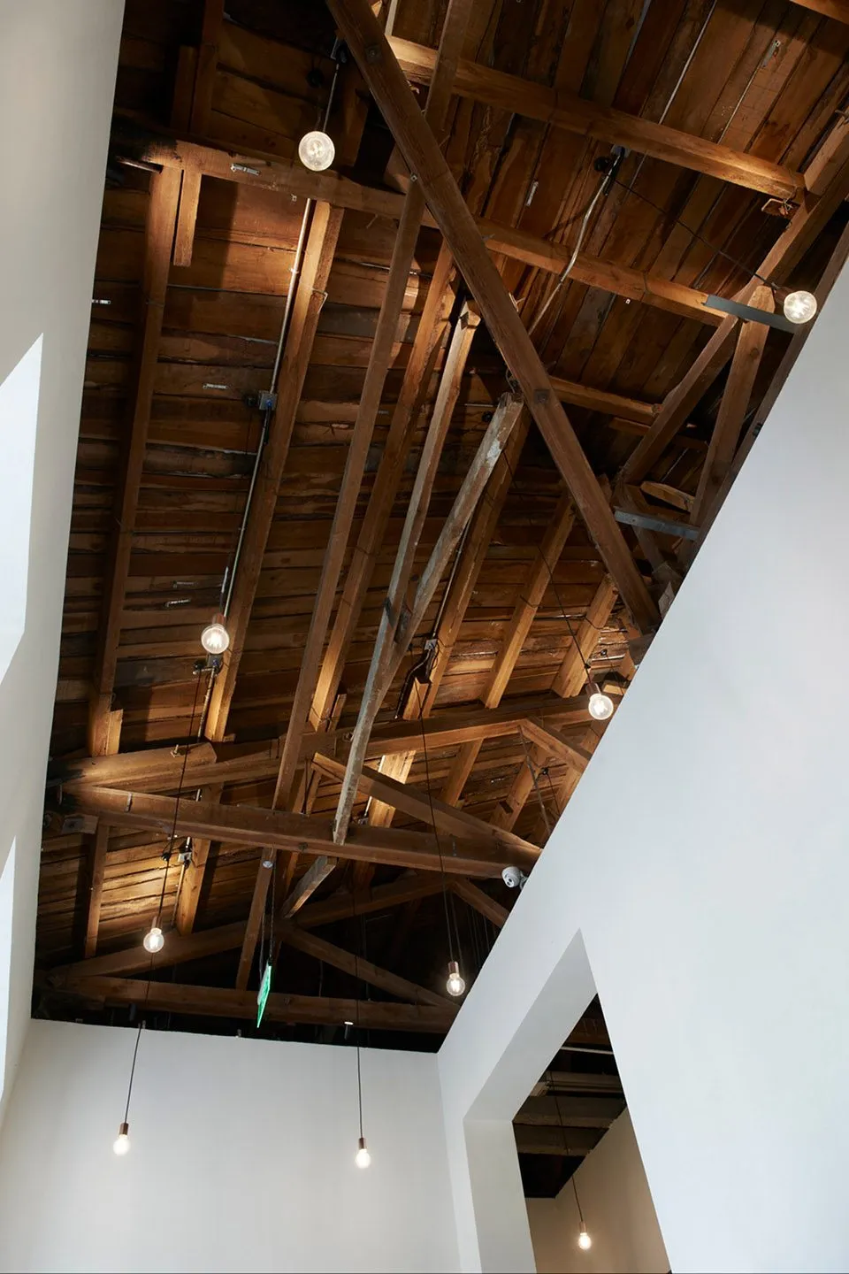 Exposed wooden ceiling beams and hanging light bulbs