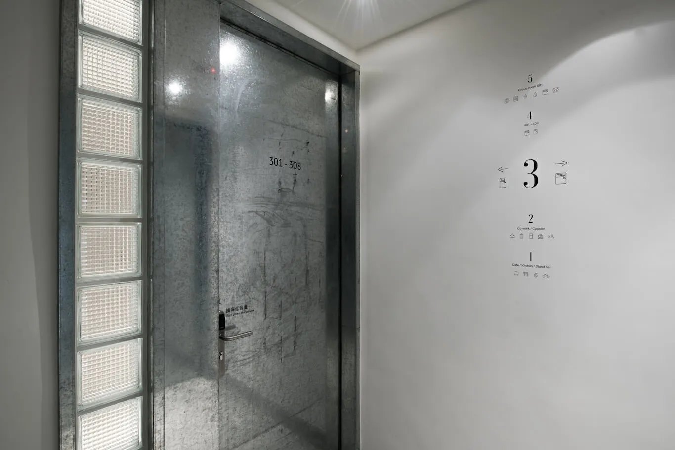 Metallic glass door with industrial design in a corporate setting.