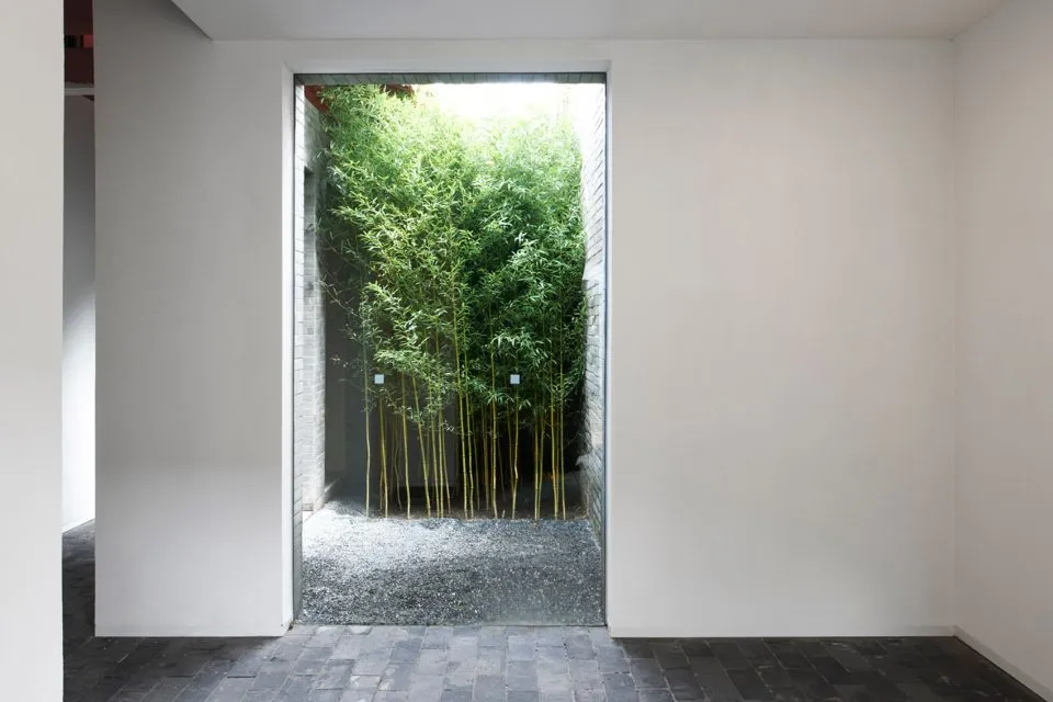 Minimalist entrance with glass, brick, and pebbles.
