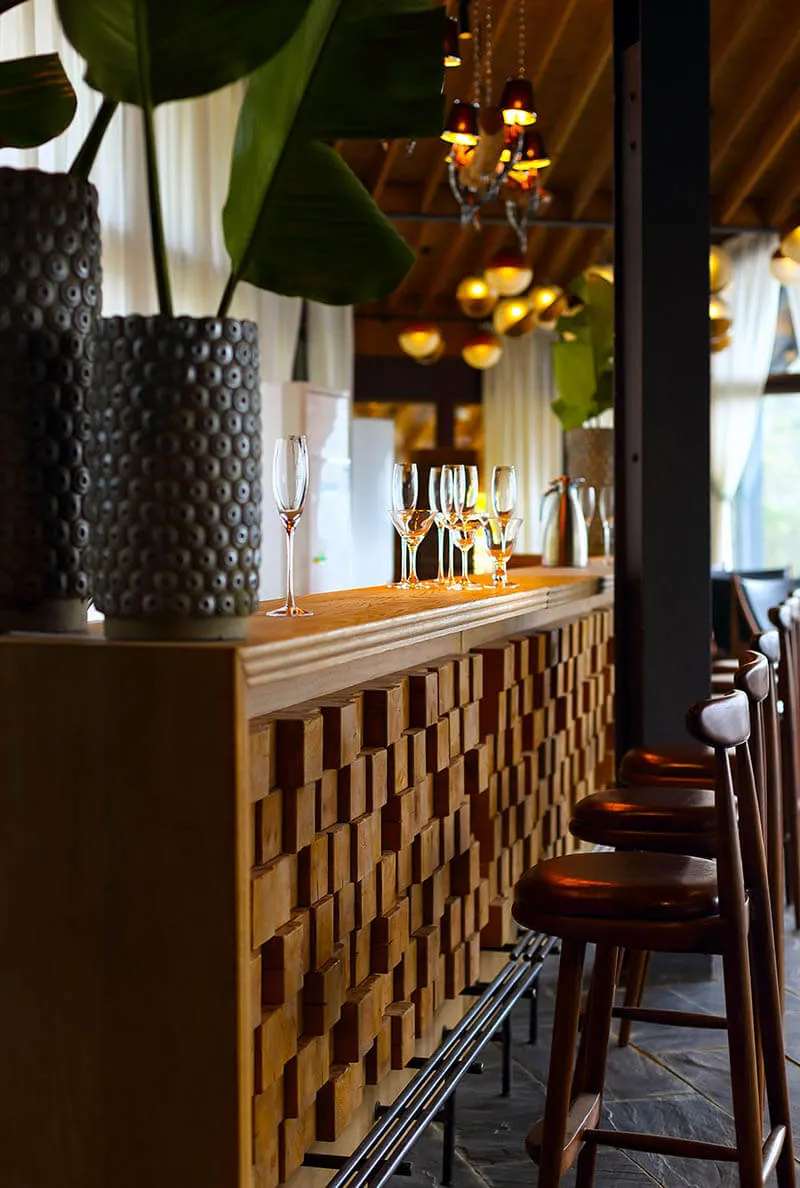 A photograph of a clean, modern bar counter with wood-texture details, showcasing sleek design.