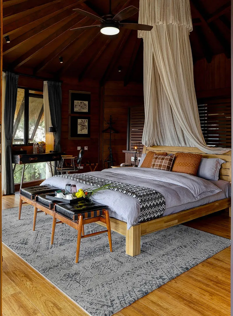 A modern, fashionable bedroom featuring wooden furniture, a canopy bed, and contemporary decor.