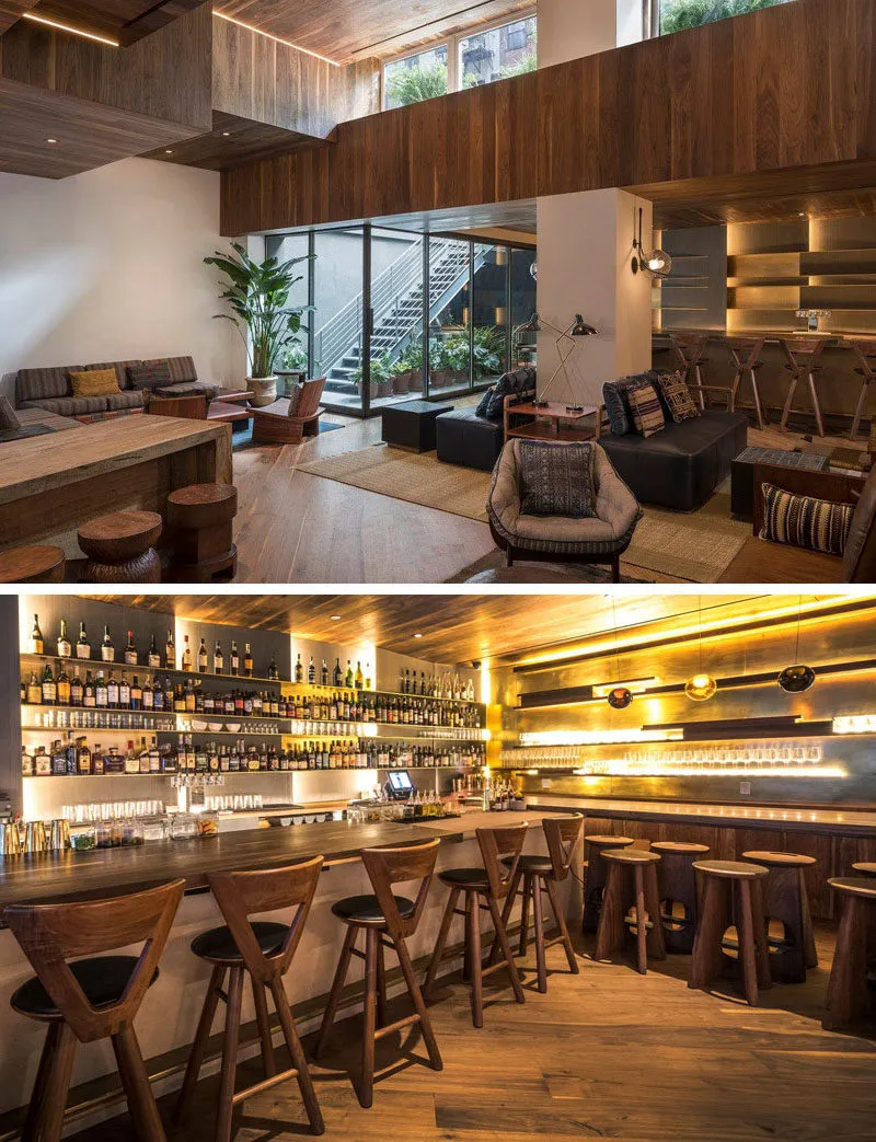 A modern bar interior with a wooden texture, featuring a well-stocked bar and wooden seating.