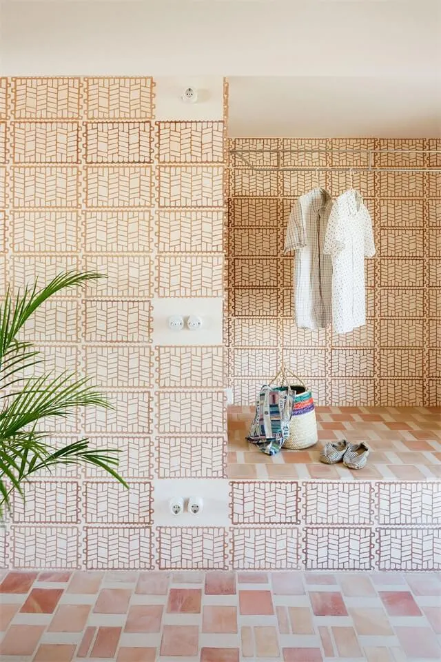 A modern laundry room with geometric patterned ceramic tile flooring and walls, featuring a clothesline and laundry basket.