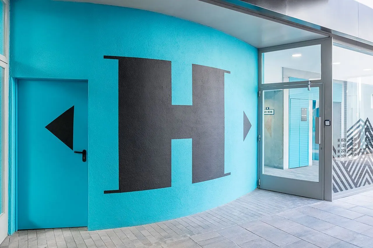 Blue painted exterior wall featuring a bold graphic design.