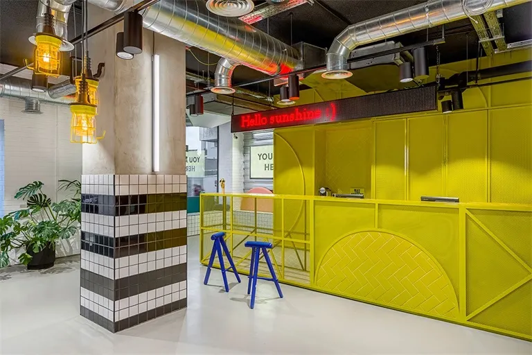 Industrial-style restaurant bar counter featuring metal, tile, and wooden elements.
