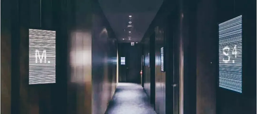 極簡風格的走廊室內,設有金屬標示牌顯示字母與符號。