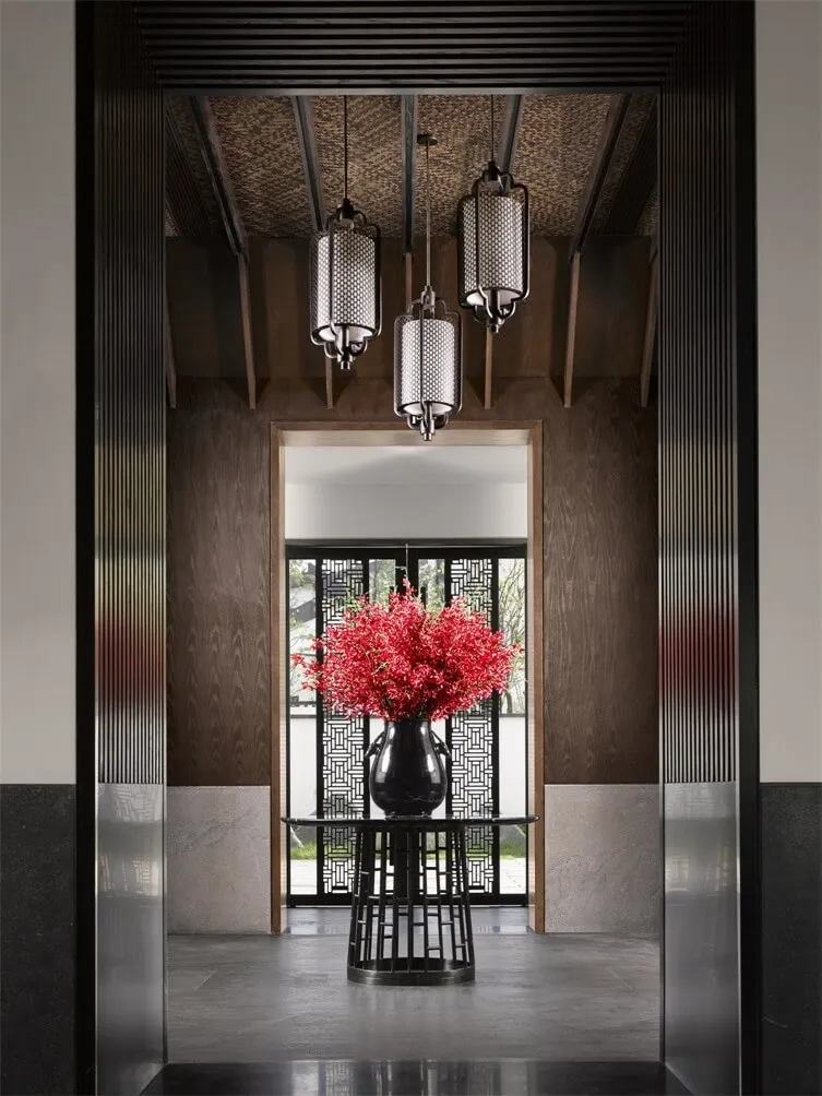 A modern interior entryway featuring a metal wall and decorative lighting.
