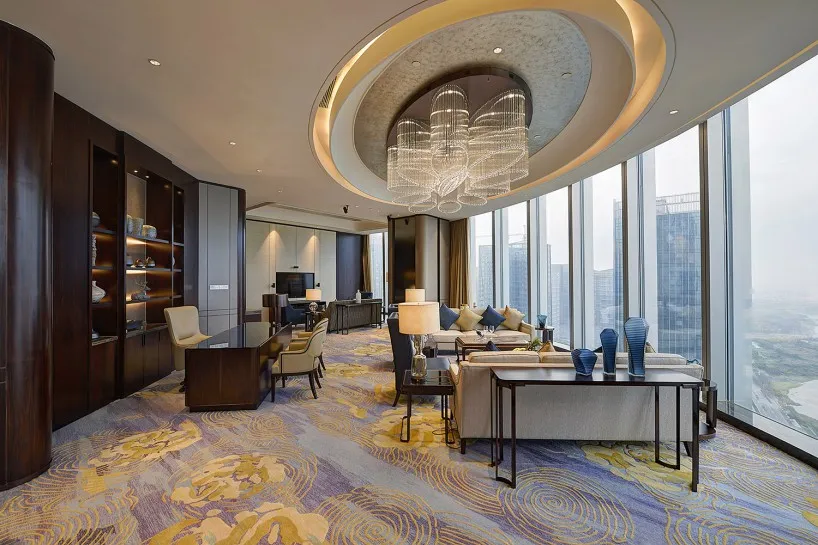 Modern lounge with glass view featuring contemporary furniture and large windows with a cityscape backdrop.