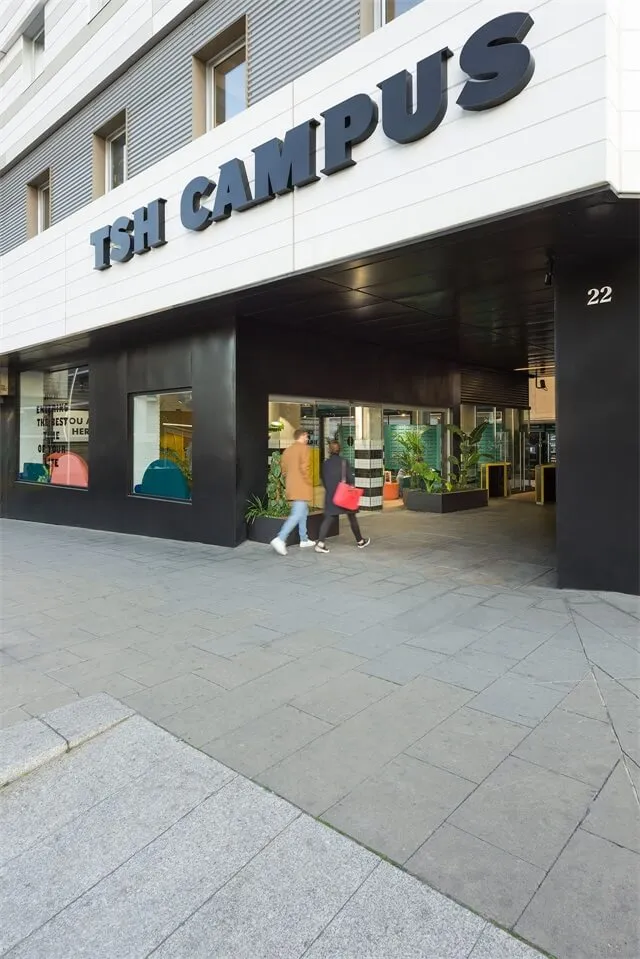 Modern storefront with concrete planters and industrial decor elements.