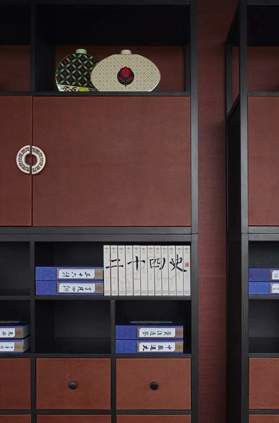 A modern metal bookshelf with books and decorative items on display.