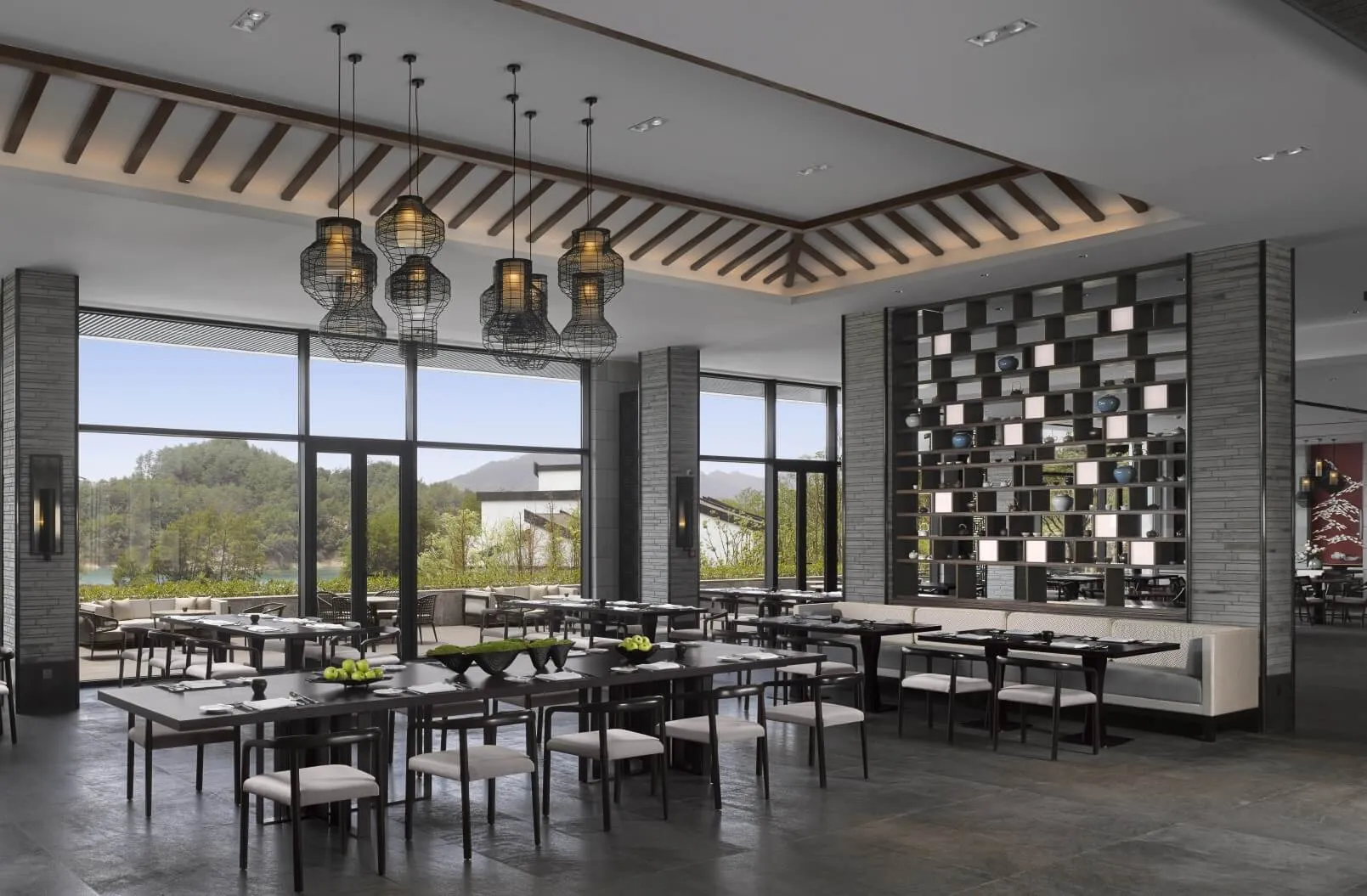 A spacious, modern restaurant interior with large windows, contemporary furniture, and minimalist decor.