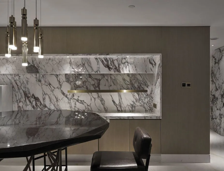 A modern kitchen featuring a marble countertop and backsplash.