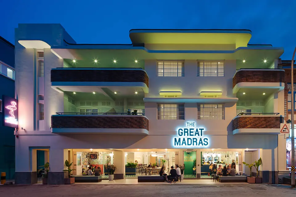 An illuminated building facade with a neon sign reading 'The Great Madras'.