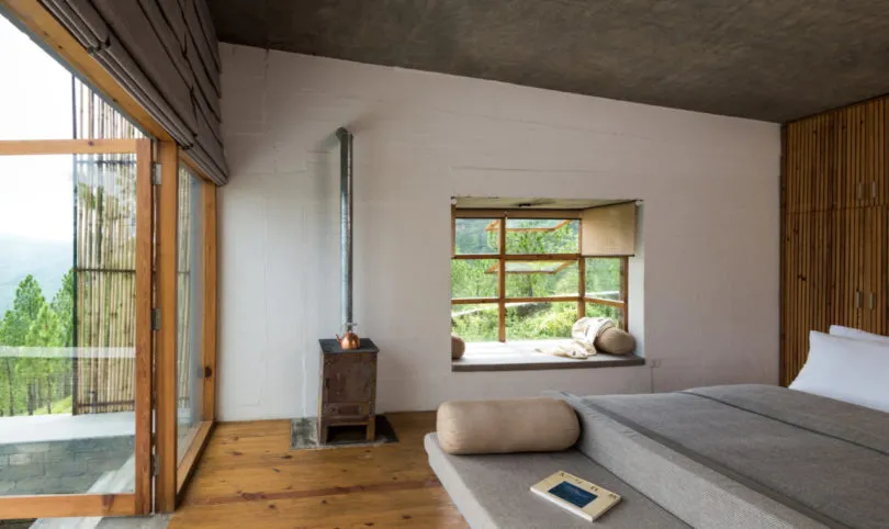 Minimalist residential space with large windows and rustic wooden elements.