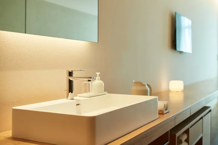 Modern bathroom with a sleek, minimalist design featuring a ceramic sink and countertop.