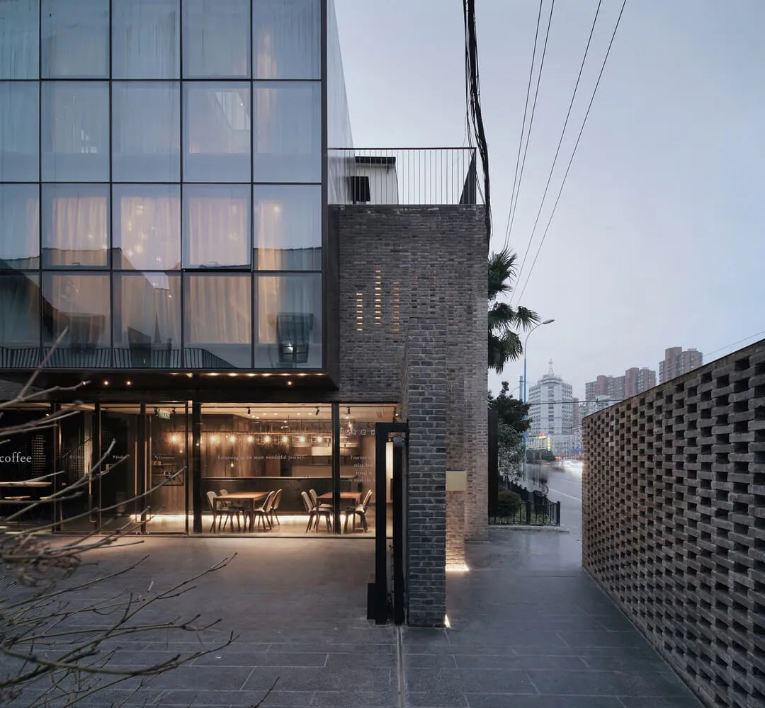 Modern industrial storefront with metal, glass, brick, and concrete elements.