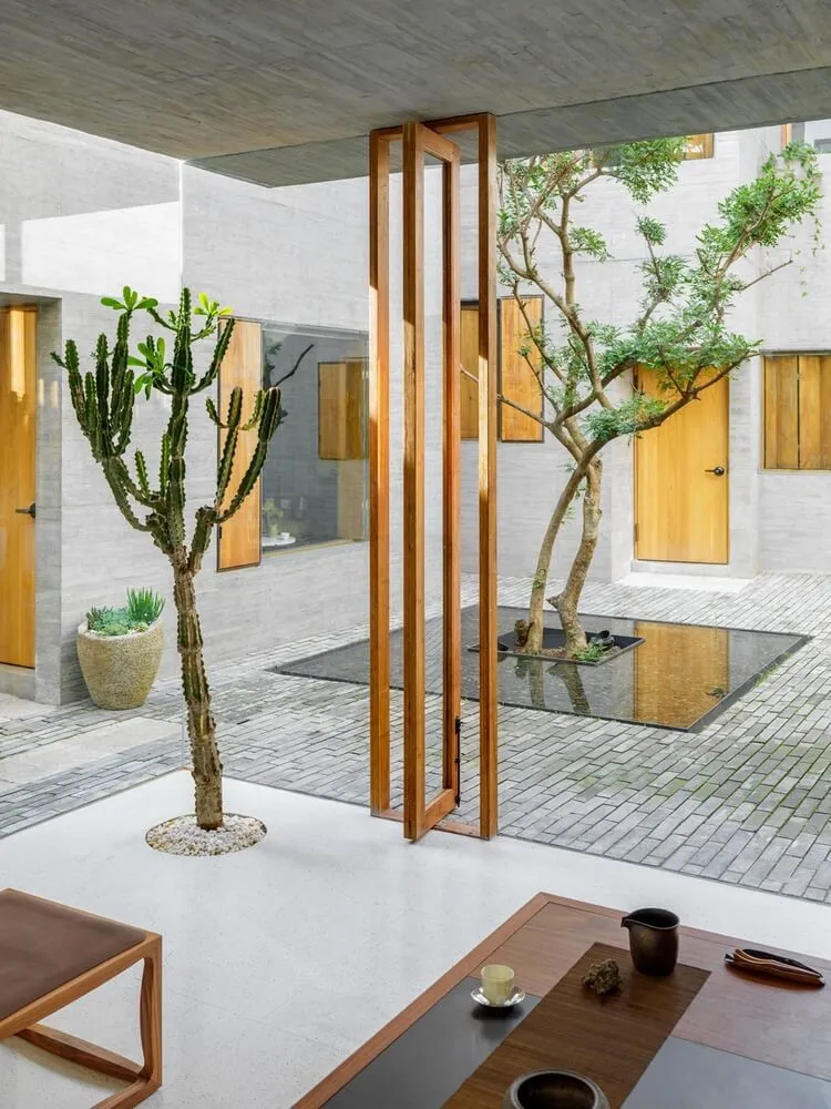 A modern living room with minimalist furniture and concrete walls.