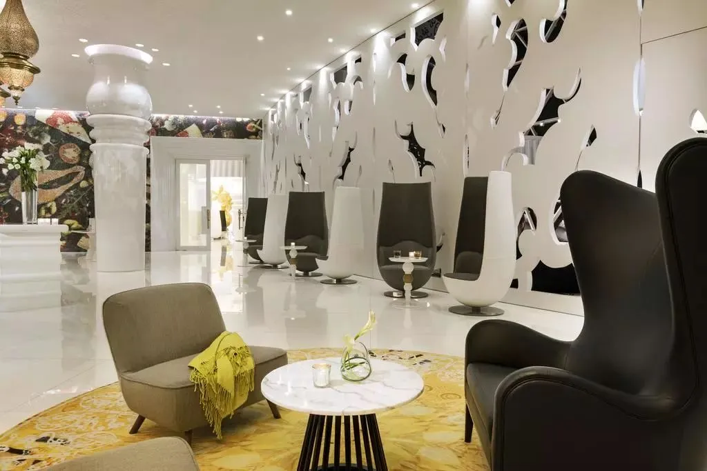 Modern, minimalist lounge area with concrete, marble, and metal accents.