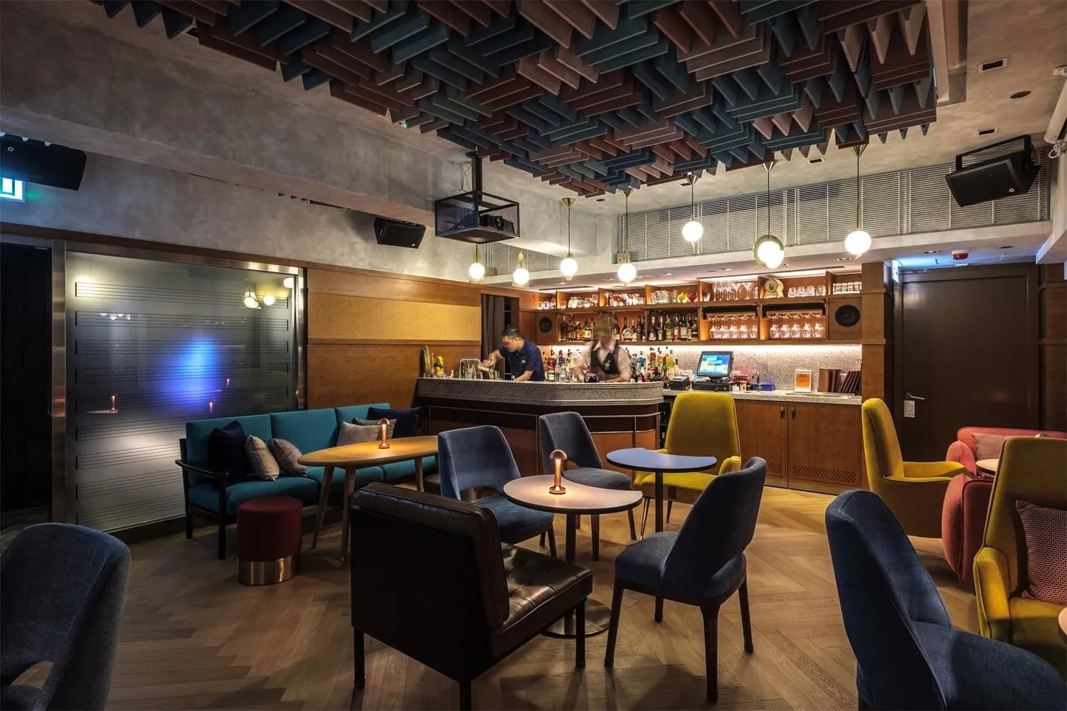 A modern restaurant and bar interior featuring concrete, wood, fabric, metal, and glass materials.