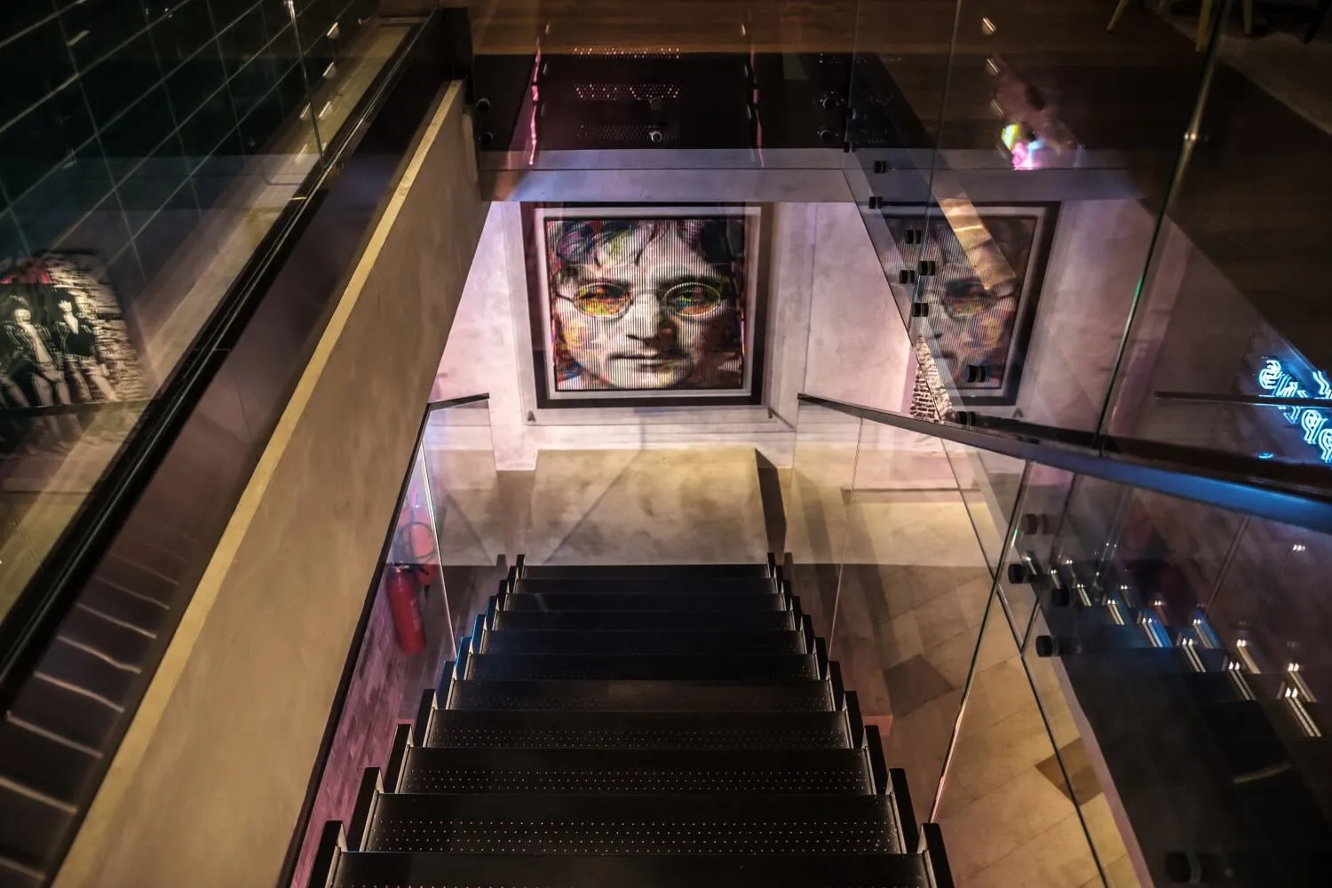 Modern staircase with glass railing, black metal steps, and contemporary design elements.