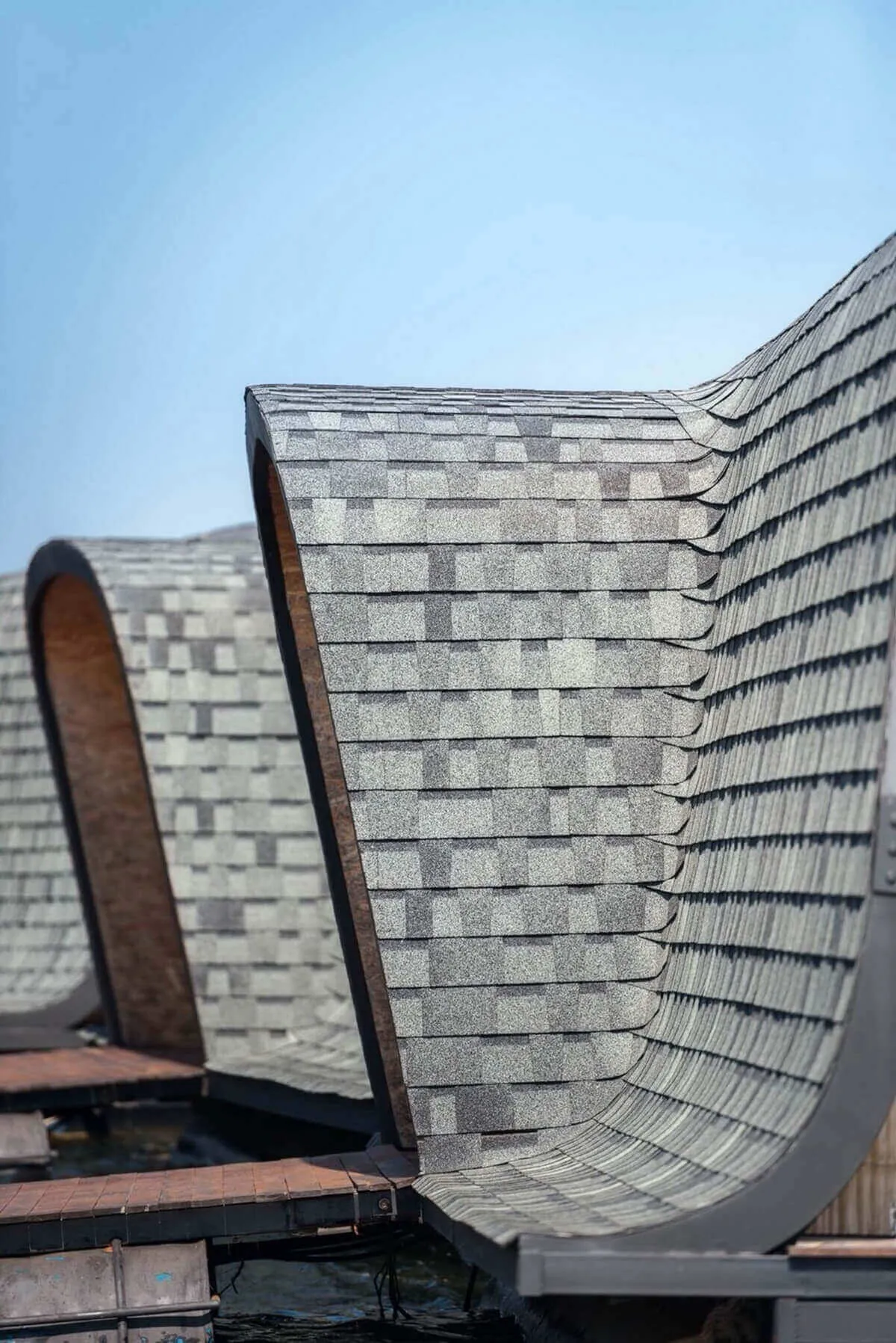 A close-up view of a floating roof with composite roof tiles on a clear day.