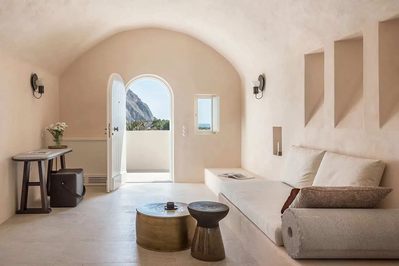 A minimalist living room with concrete flooring, a leather sofa, and a small table.