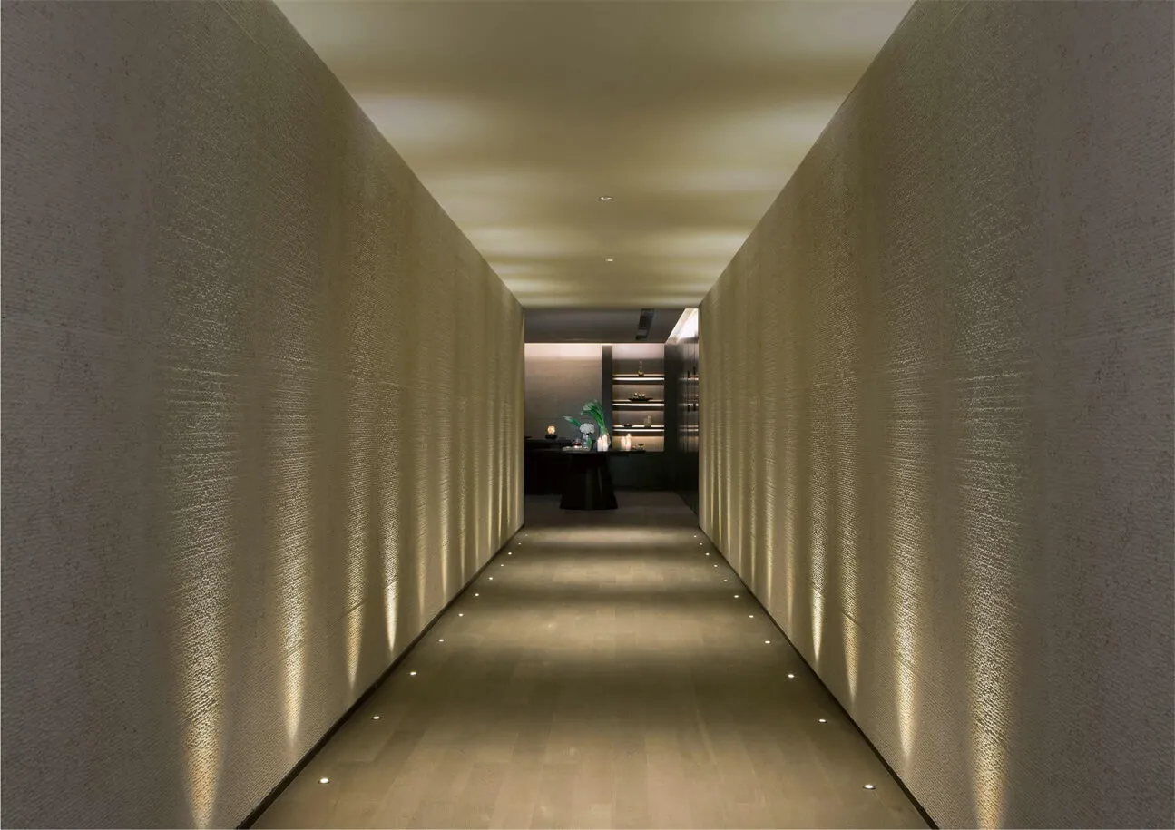 A minimalist corridor with textured walls, soft lighting, and a modern aesthetic.
