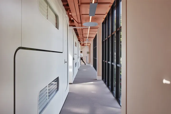 A modern office space featuring a steel wall panel and large windows.