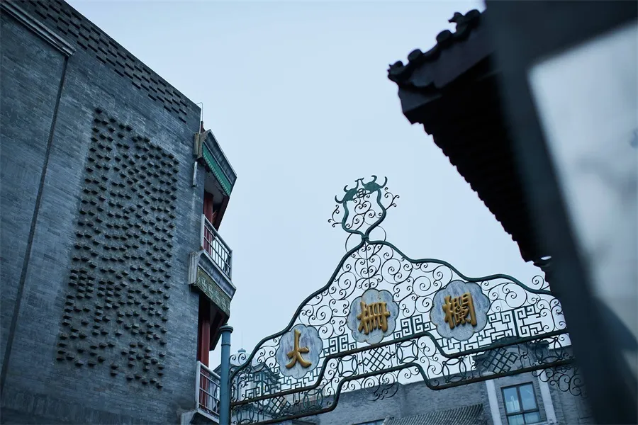 A traditional Chinese architectural gate adorned with ornate metalwork and Chinese characters.