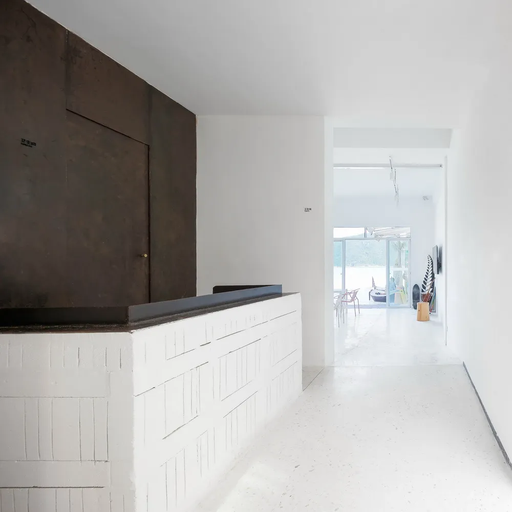 A minimalist commercial interior showcasing white concrete walls and flooring.