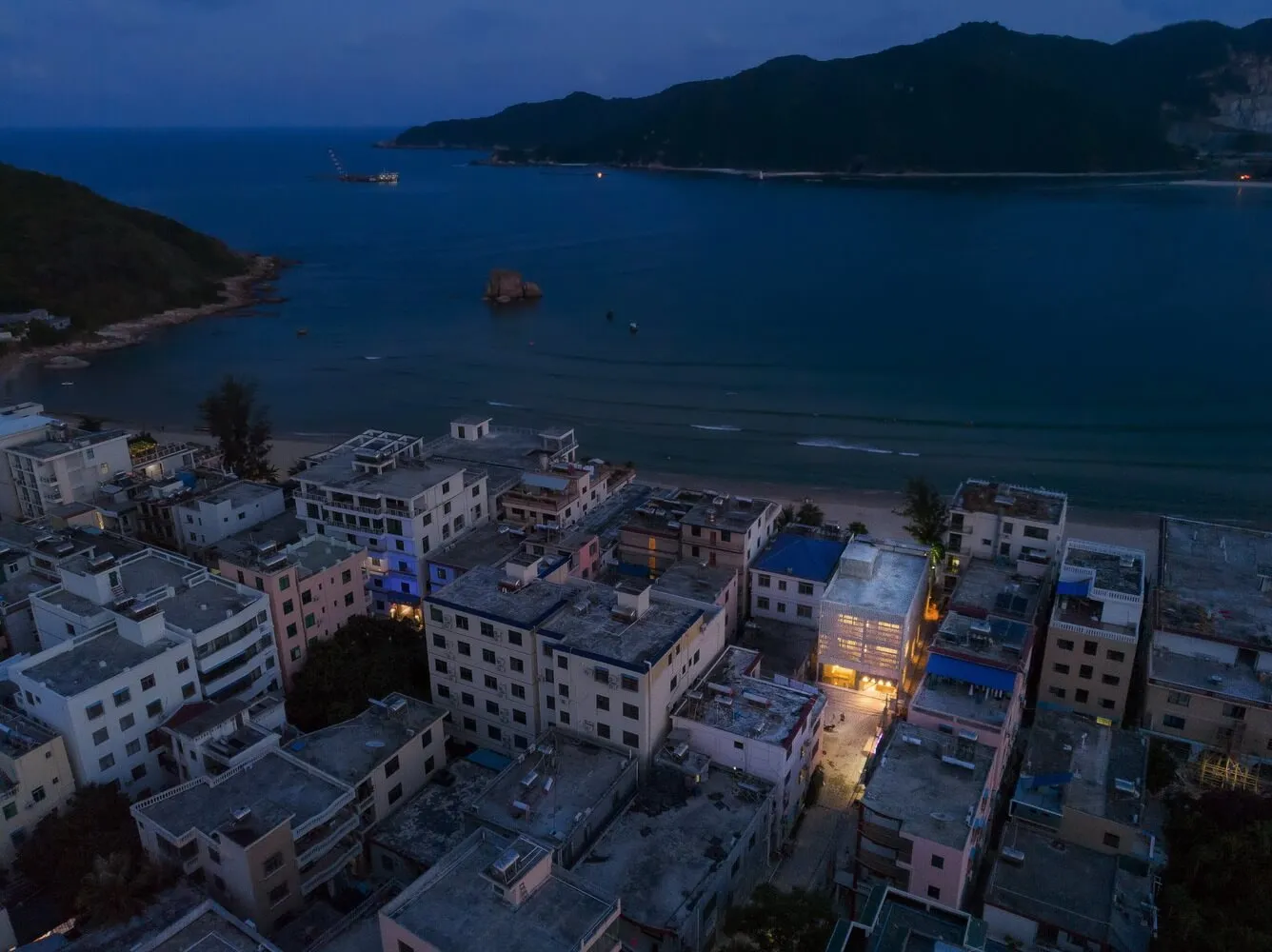 Aerial view of modern architectural design featuring concrete structures by a body of water.