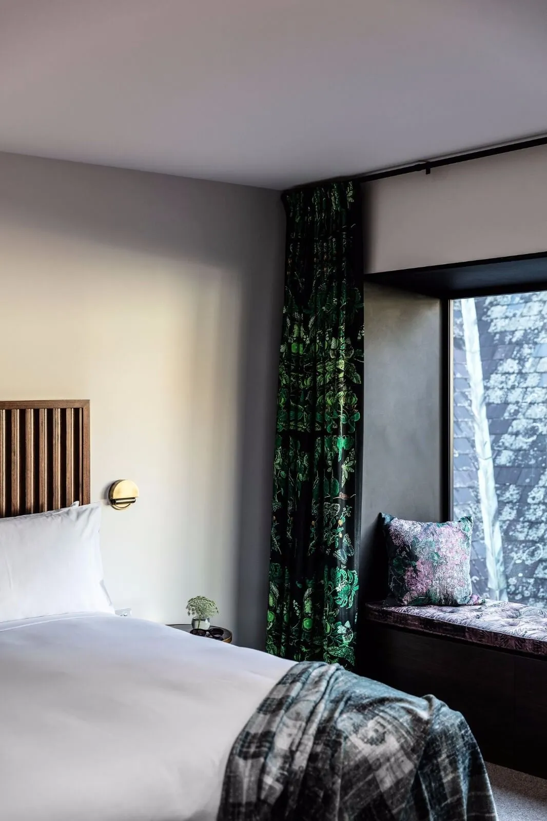 A modern bedroom with clean lines, a green and white color palette, and a focus on fabric materials.