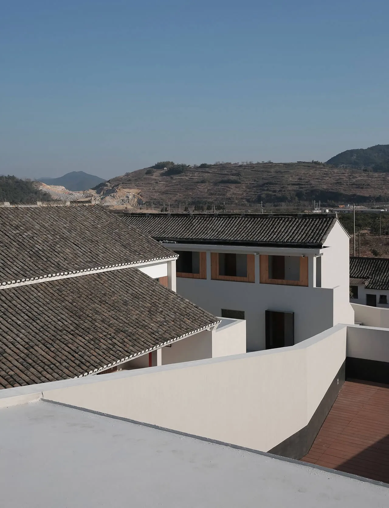 Modern residential building with white tiled roof and white walls.