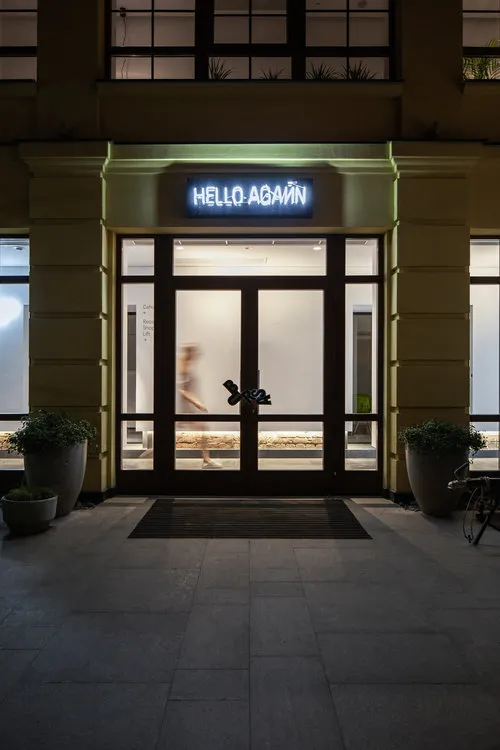A modern, minimalist building entrance featuring large glass doors.
