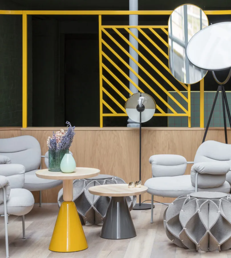 A modern living room featuring stylish furniture, a yellow table, and geometric design elements.