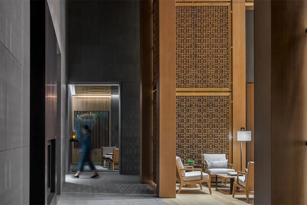 A modern lobby featuring wooden paneling and contemporary furniture.