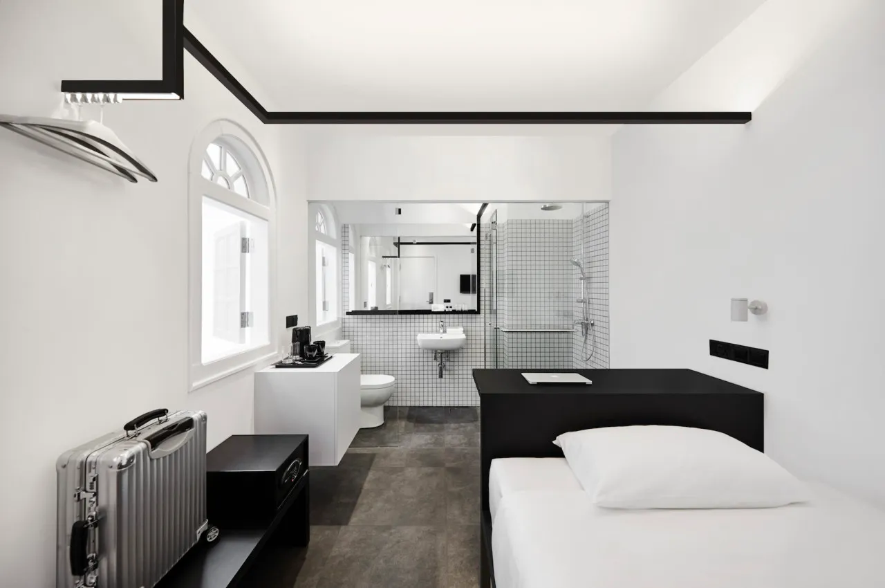 a modern minimalist bedroom with white walls and black accents
