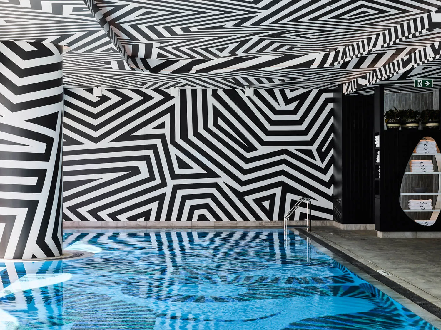 Swimming pool interior with black and white geometric patterns on the walls and ceiling.