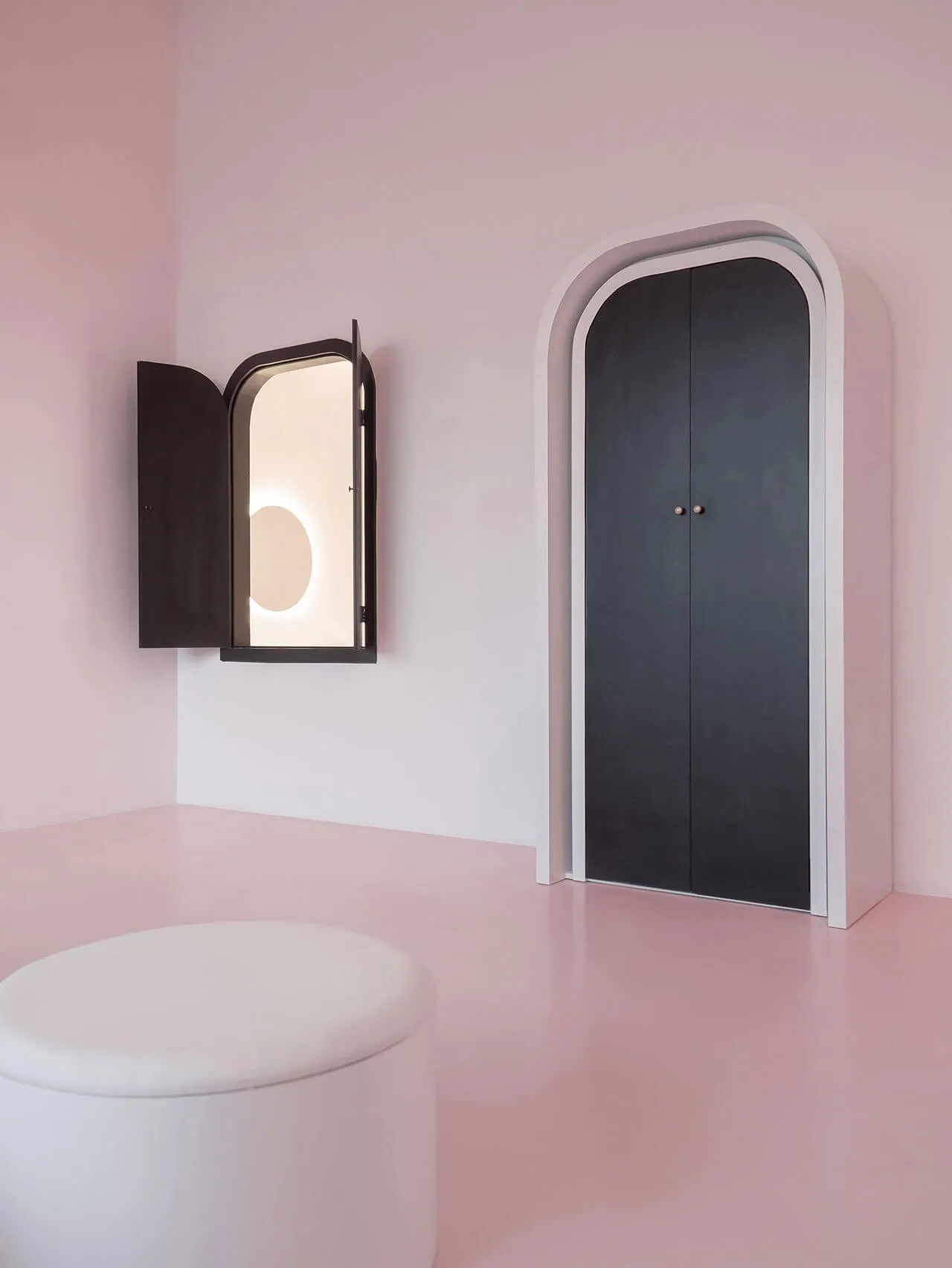 A minimalist interior design featuring arched lighting and walls made of plaster and metal.